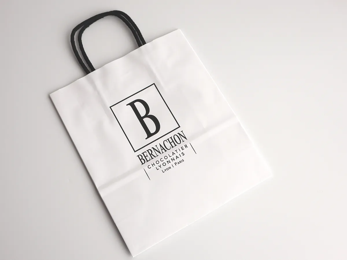 ベルナシオンのロゴが入ったシンプルで洗練されたデザインの専用ショッパー（紙袋）